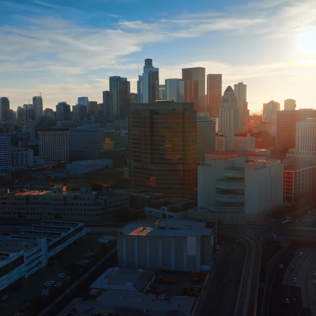 Spindrift cloudscape over the beautiful Los Angeles downtown. Beautiful skyscrapers dropping shadows on the city. Sunny sky at backdrop