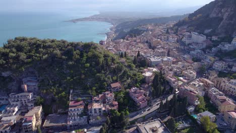 Toma-Aérea-De-Taormina,-Sicilia,-Italia,-Un-Famoso-Destino-Turístico-Rodeado-Por-Aguas-Color-Esmeralda