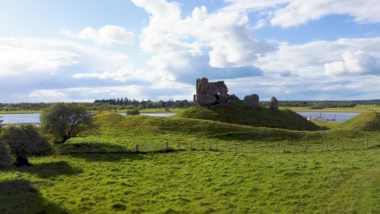 un dron que se eleva hacia adelante del río shannon como telón de fondo del antiguo monasterio de clonmacnoise en el condado de offaly irlanda
