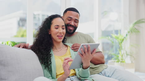 Couple,-tablet-and-laugh-on-home-sofa-together