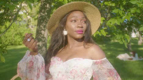 Mujer-Negra-Viendo-Ajustar-El-Cabello-En-Un-Picnic-En-El-Parque-Contacto-Visual-De-Cerca