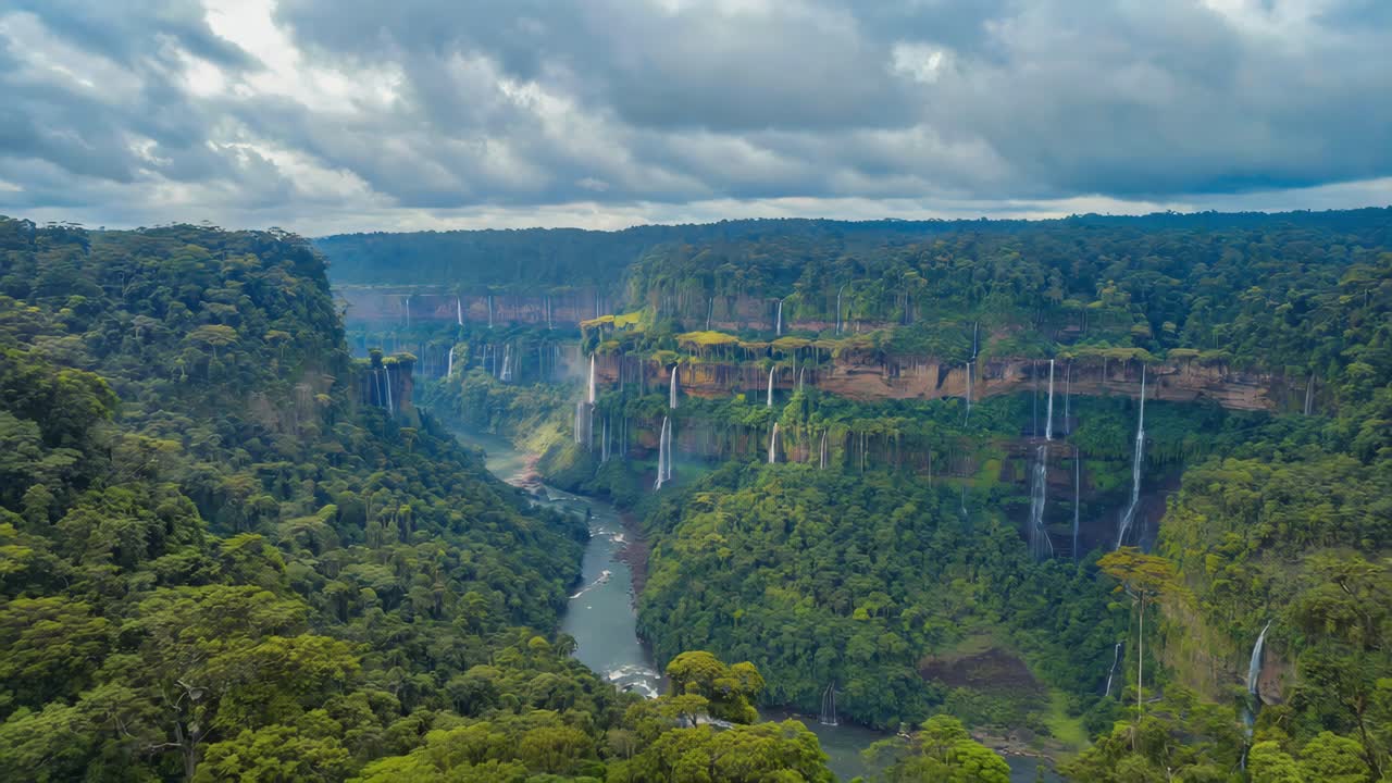 Lush Green Jungle Landscape with Numerous Waterfalls Cascading into a River Canyon