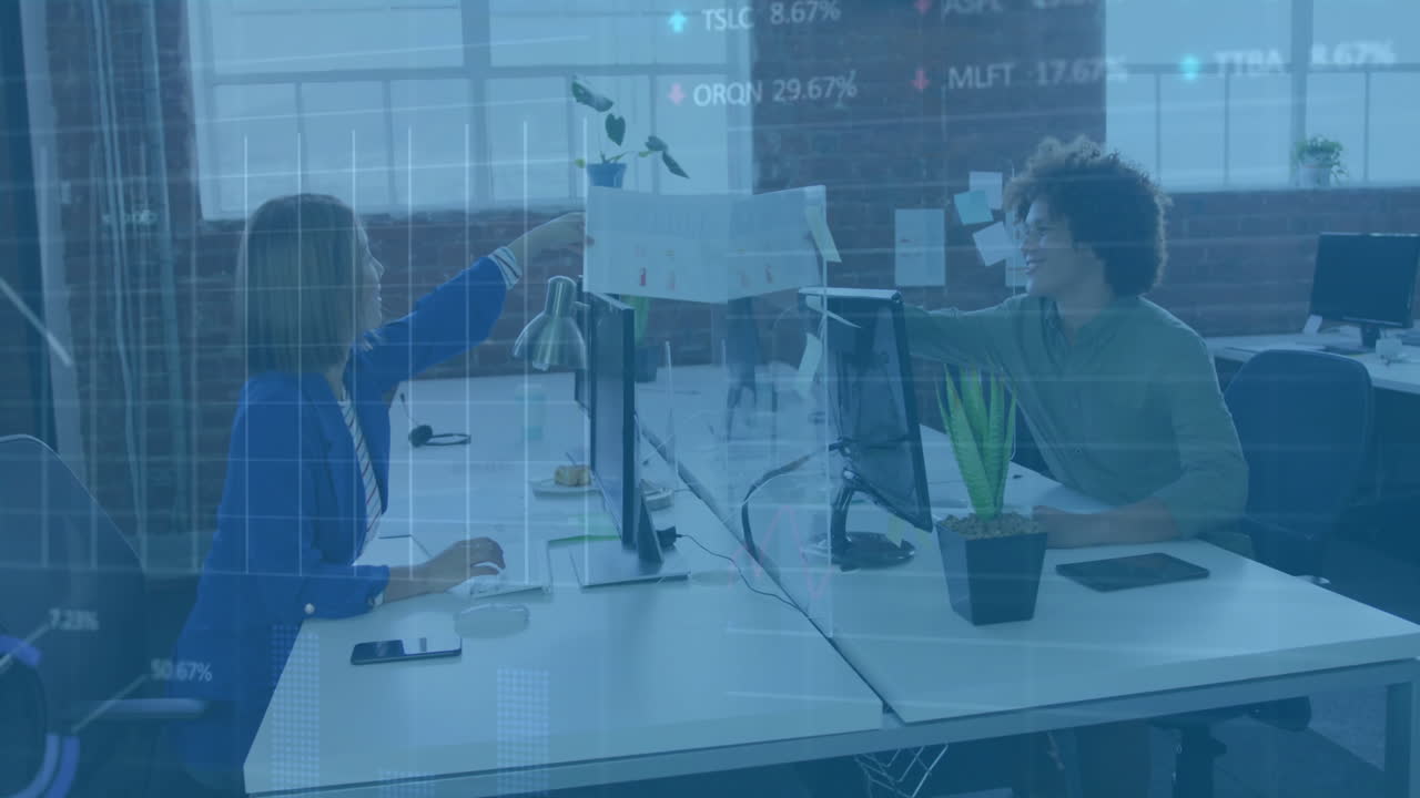 Exchanging documents, colleagues at office desk with stock market animation overlay