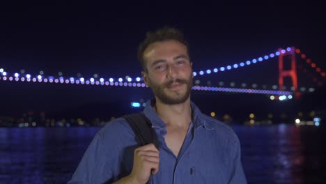 joven mirando a la cámara y sonriendo. garganta en la noche.