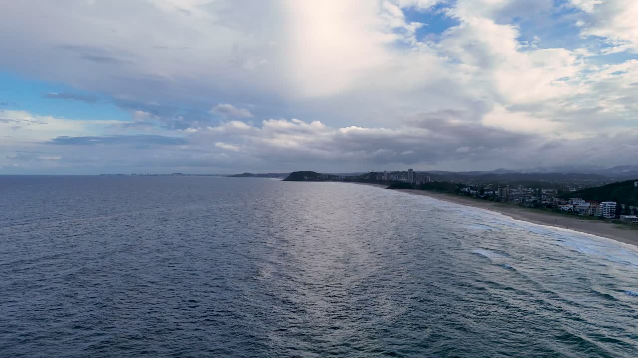 다채로운 해가 지는 하늘 아래의 바다 파도