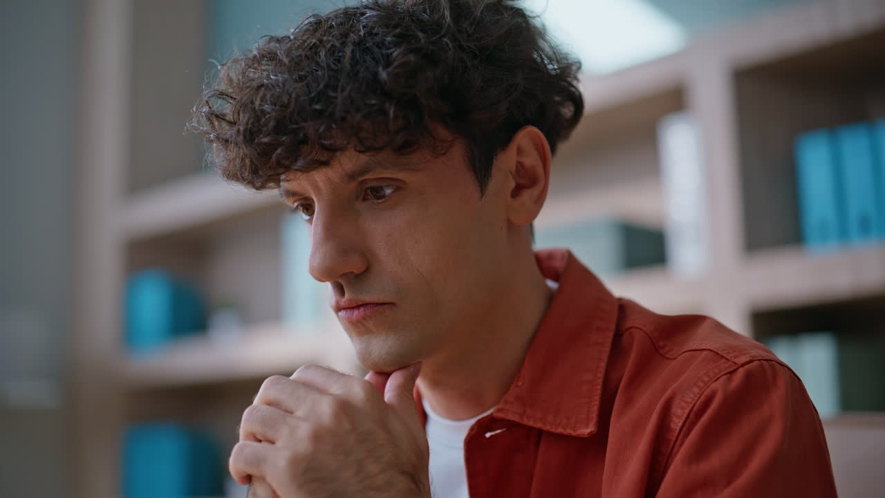 Pensive entrepreneur contemplating idea in creative agency workplace closeup