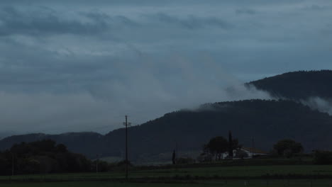 timelapse zoom in of the movement of the clouds after a storm in a small catalan town, the shot ends when night falls