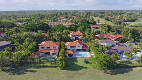 aerial trucking shot of metro country club with luxury villa and swimming pool during sunlight in juan dolio