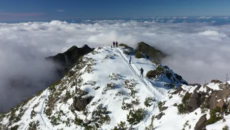 un grupo de personas caminan por el sendero desde la cima de la montaña pico ruivo en madeira