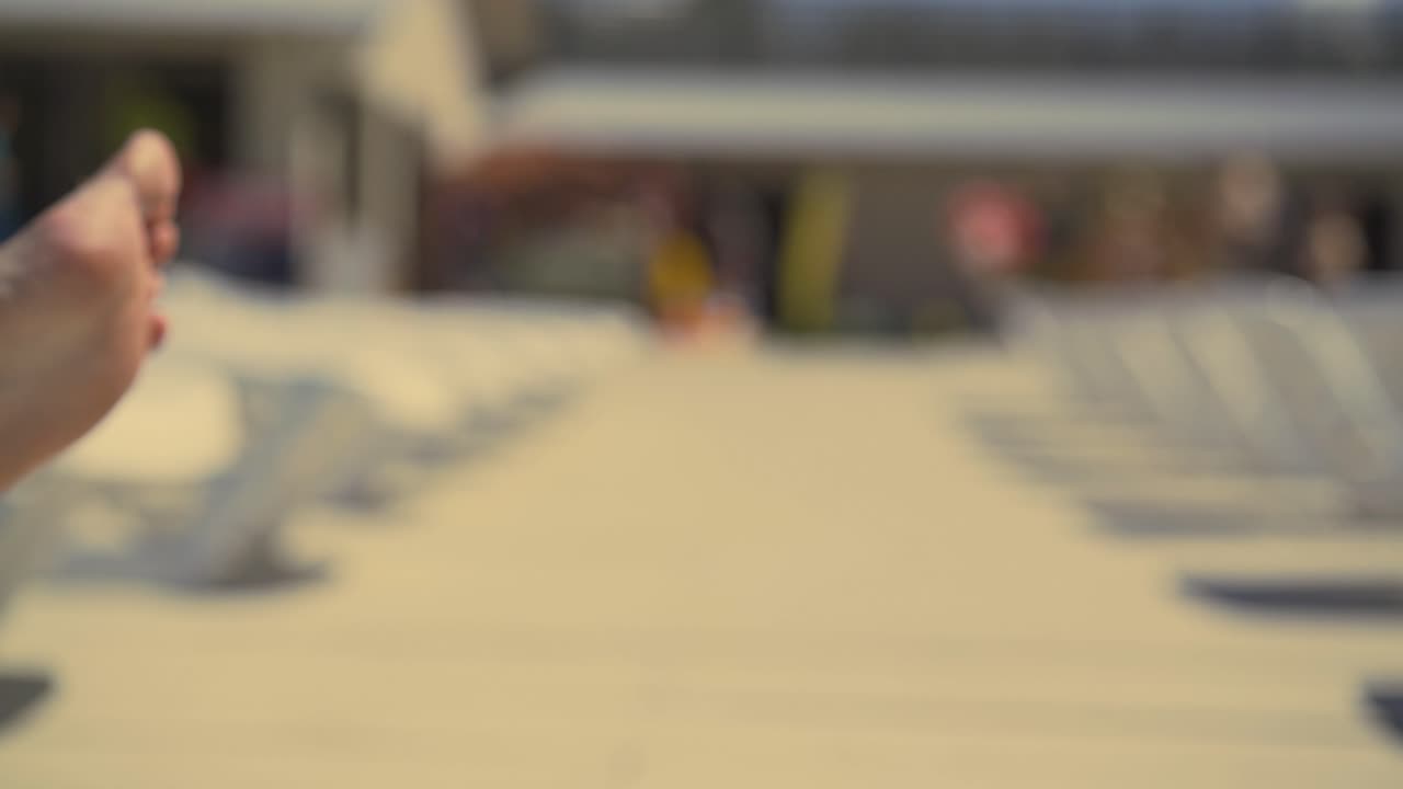 cerca de las piernas masculinas de un hombre acostado en una tumbona en la playa y baños de sol