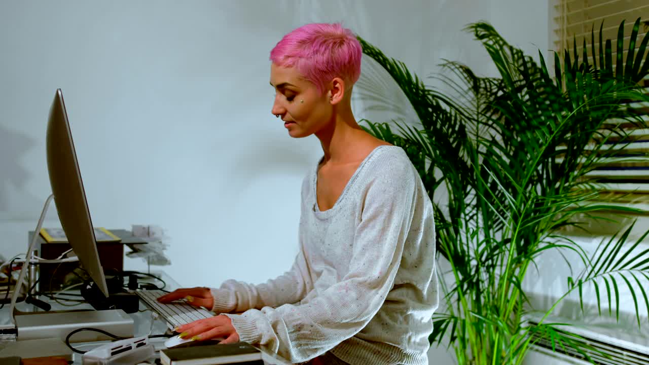 Pink hair woman working on computer 4k