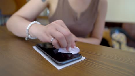 Mujer-De-Cultivo-Rociando-Detergente-En-El-Teléfono-Inteligente