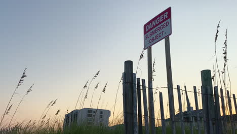 Gefahrenzeichen-Am-Strand.-Sonnenuntergang.-Hohes-Gras-In-Dünen