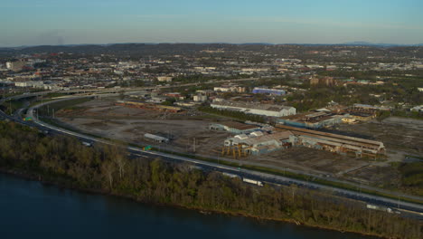 slow aerial footage rotating around an abandoned steel factory with the tennessee river and highway 24 in the foreground