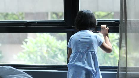 child girl looking through window ,