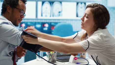 physician doing a medical consultation with blood pressure monitor