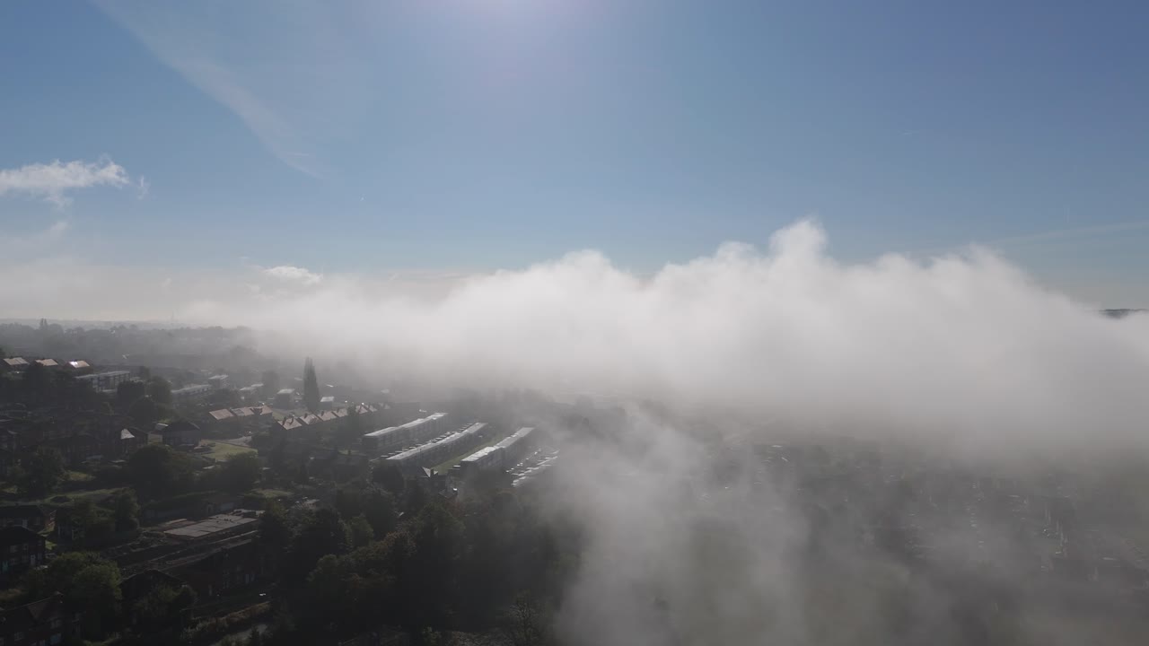 Suburban landscape covered by thick morning mist and fog, Small town of Dewsbury and Heckmondwike. Cold winter Yorkshire morning. Cityscape with homes rooftops and busy roads. Winter scene