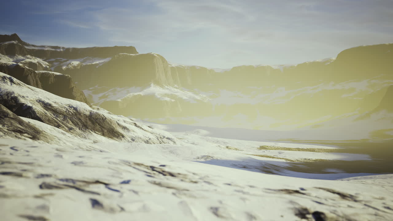 Snowy mountain landscape under a soft golden light at dawn