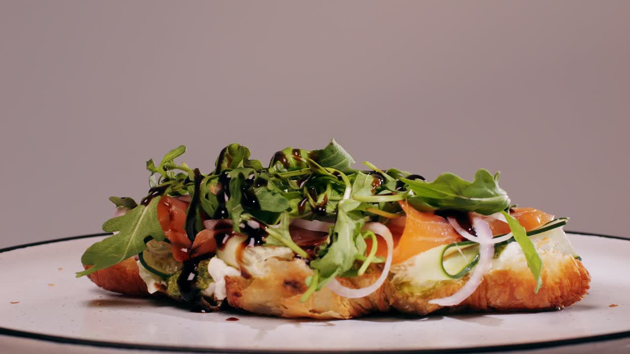 Croissant with jamon ham, Salmon, in Modern Cafe, Top View of Healthy Breakfast in Cafe. English breakfast: fried egg, bacon toast on sandwich.