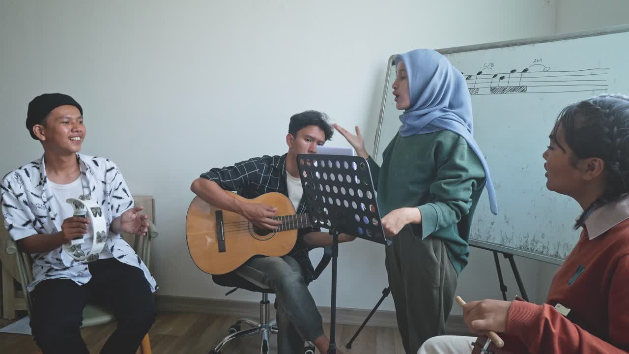 Asian Woman Singing While Colleagues Playing Musical Instrument