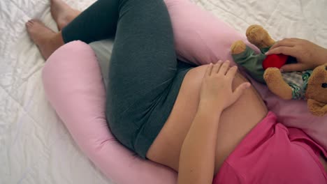 mujer embarazada feliz durmiendo en la cama en el dormitorio.