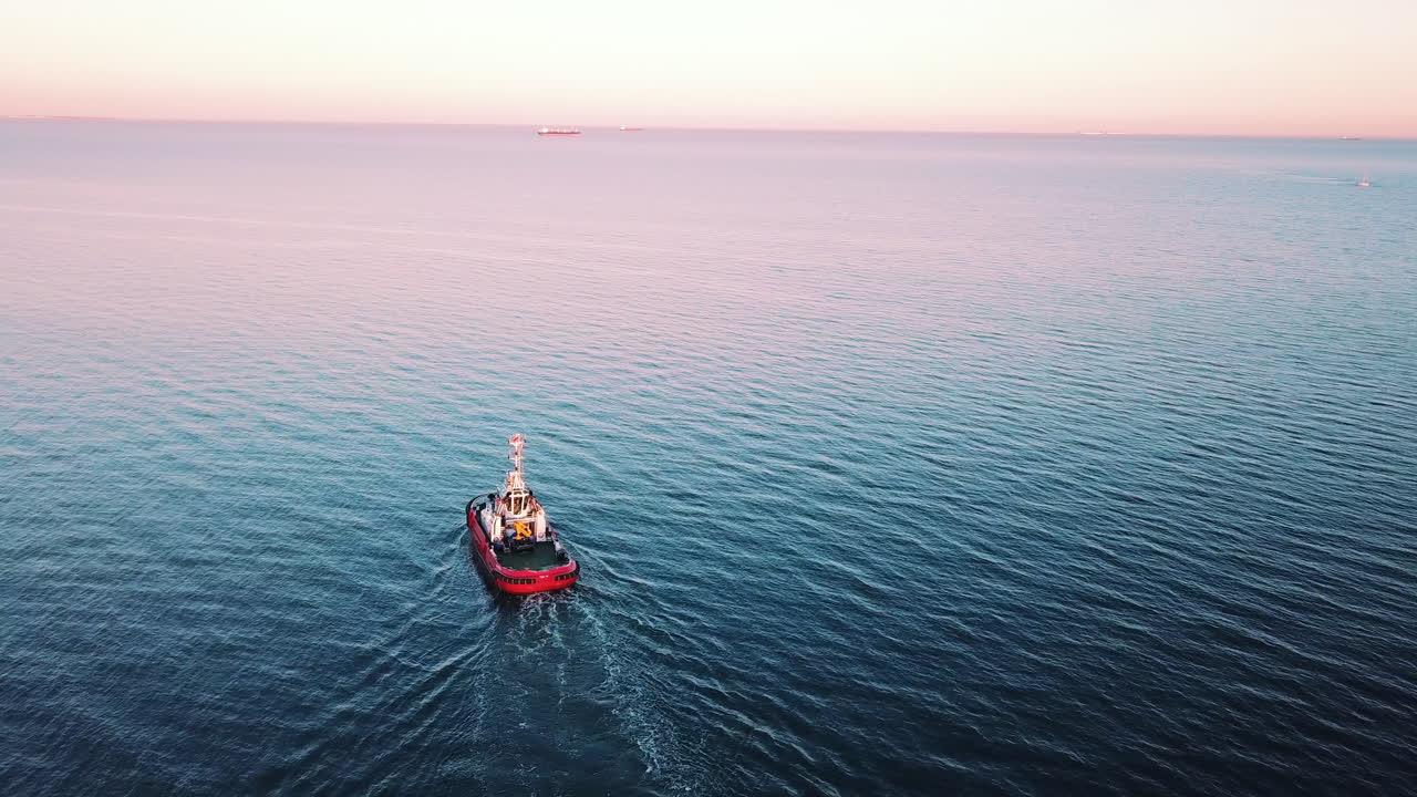 drone volando alrededor de un barco de pesca navegando en el mar al atardecer-1