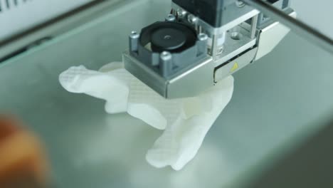 la moderna impresora 3d imprime figuras de primer plano macro. la impresora tridimensional automática 3d realiza el modelado de colores blancos de plástico en el laboratorio. el procesamiento de impresión 3d con fondo blanco