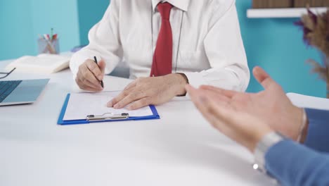 male psychiatrist listening to adult stressed male patient and writing notes in psychologist office.