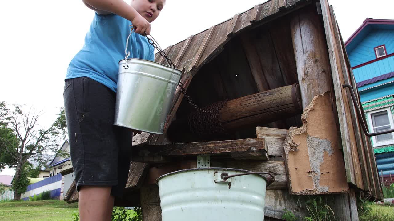 다른 버에서 물로 버을 채우는 소년의 클로즈업입니다.