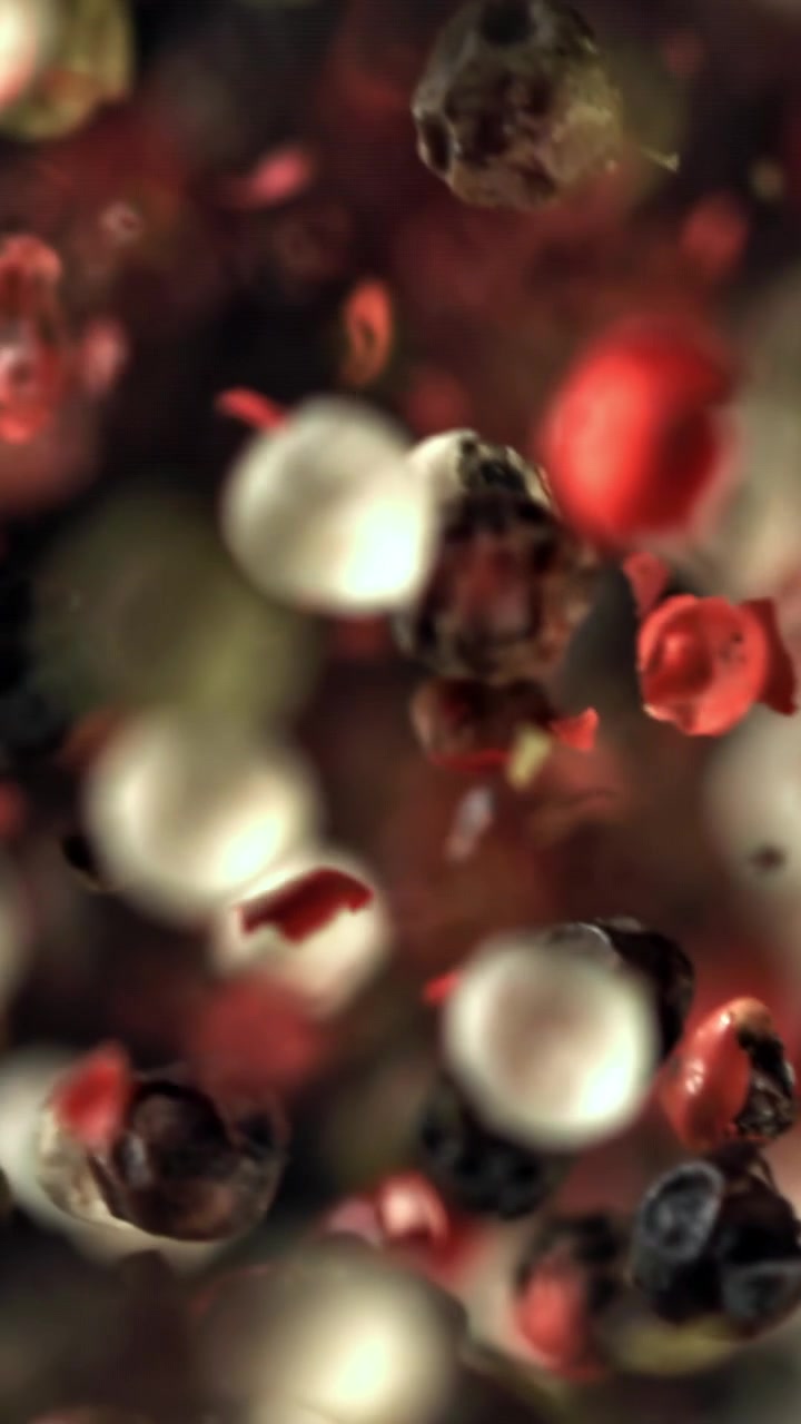 Mixed Peppercorns Falling and Swirling in Slow Motion
