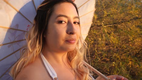 una hermosa chica agitando un paraguas en blanco.