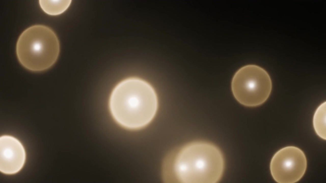 Sfondo astratto di sfere di luce dorata luminose su nero
