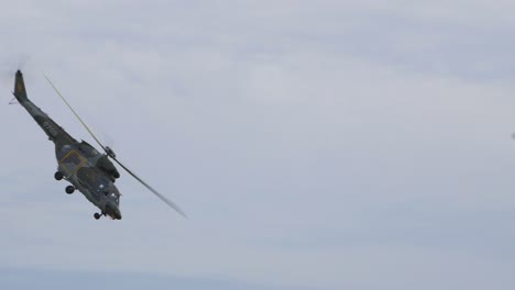 plz w-3 sokol sars helicopter flying slowly sideways with slow rotation at baltic international airshow, handheld shot, 4k