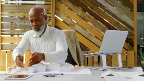 Executive-working-on-architectural-model-at-desk-in-the-office-4k