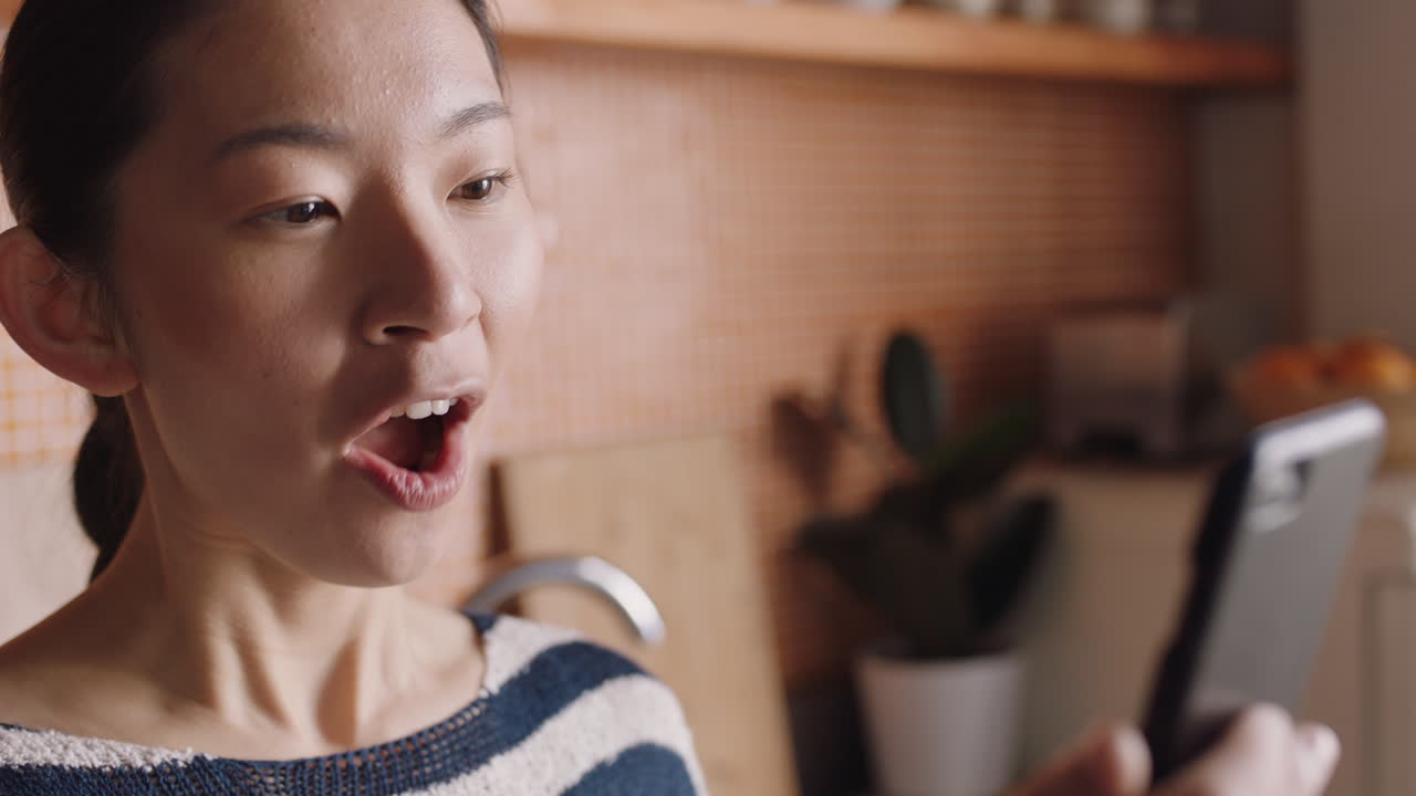 행복한 여성이 집에서 스마트폰을 사용하여 비디오 채팅을 하고 친구와 채팅을 하고 휴대 전화로 대화를 즐기며 라이프 스타일을 공유하고 있습니다.