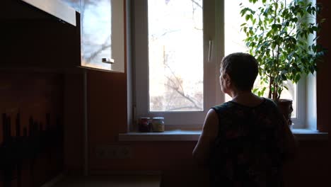 elderly woman looking out of a window