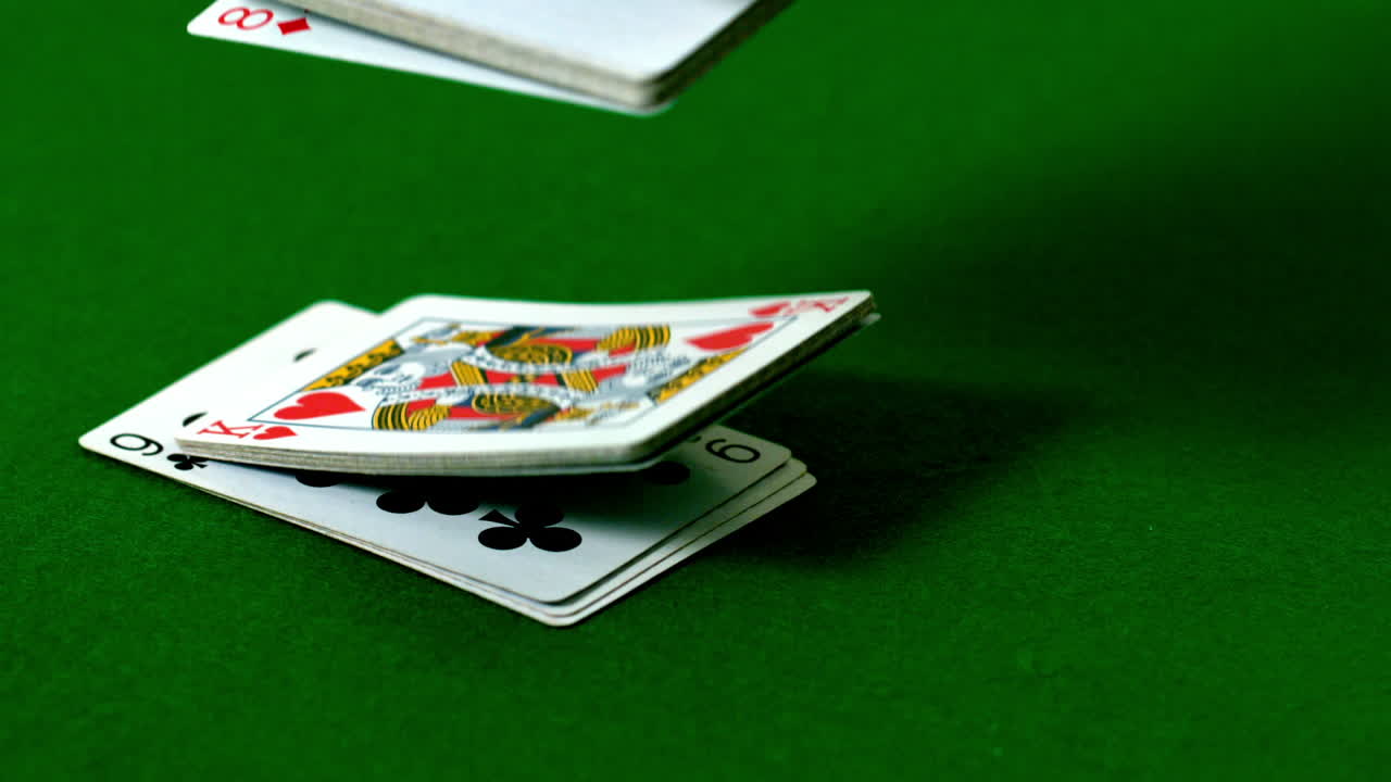 una baraja de cartas cayendo sobre la mesa del casino