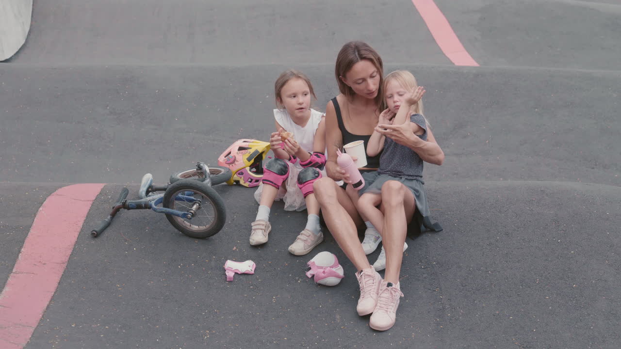 mujer y dos niños comiendo al aire libre