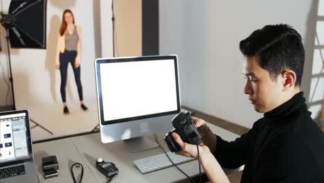 Photographer-reviewing-picture-on-digital-camera-during-photo-shoot