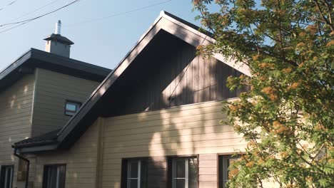 beige house with brown trim and trees