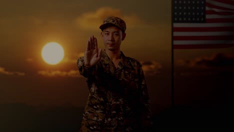 soldier with stop gesture against sunset and american flag