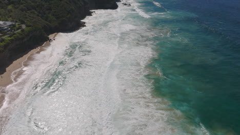 Rough-ocean-waves-hitting-shoreline-with-dense-vegetation