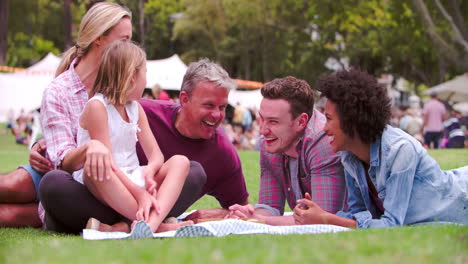 Two-couples-and-a-girl-relaxing-together-at-an-outdoor-event