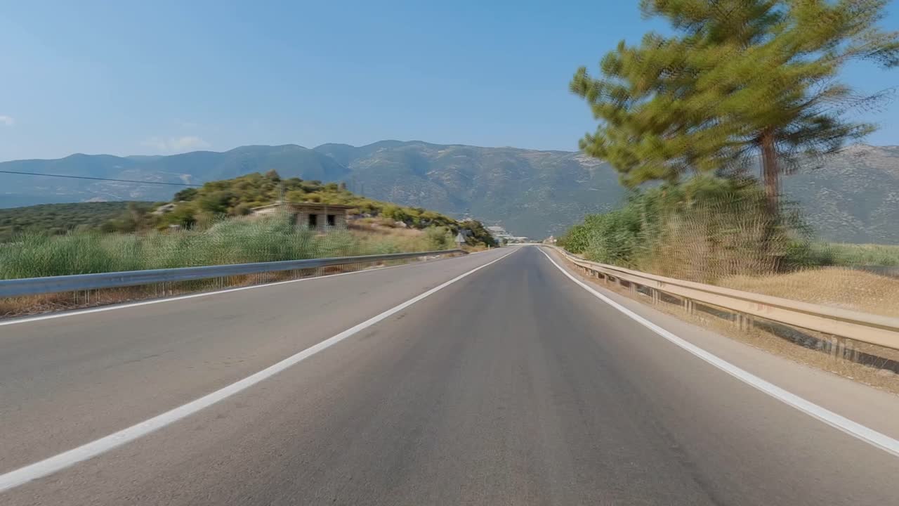 Fast driving on a Turkish road running along the sea, with a mountain view in the background