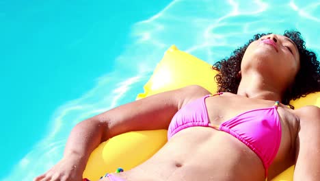 Gorgeous-woman-in-swimming-pool-lying-on-lilo