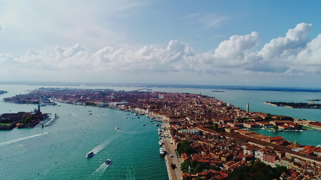 Drone lifts above Venice showing vibrant waterways and terracotta rooftops, 4K