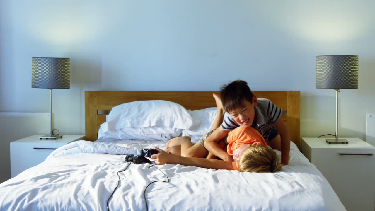 형제 자매가 침실에서 침대에서 재미를 느끼고 있습니다.