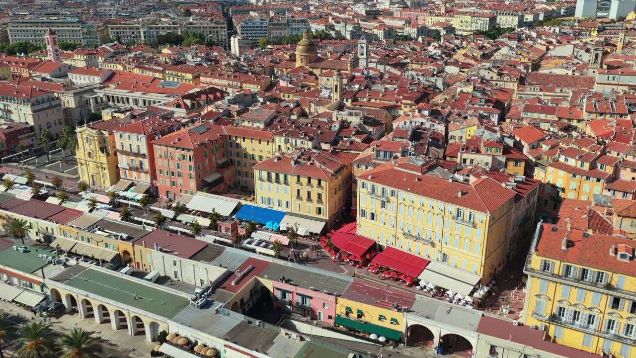 Aerial drone view of Nice Old Town with colorful buildings, terracotta rooftops, and busy beachfront