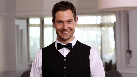 handsome waiter smiling at camera