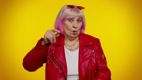 una anciana apuntando a la cámara y mostrando un gesto estúpido, culpando a un idiota por un plan loco.